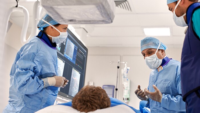 Three doctors talking to a patient