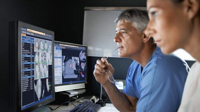 Two clinicians checking the CT images of a patient